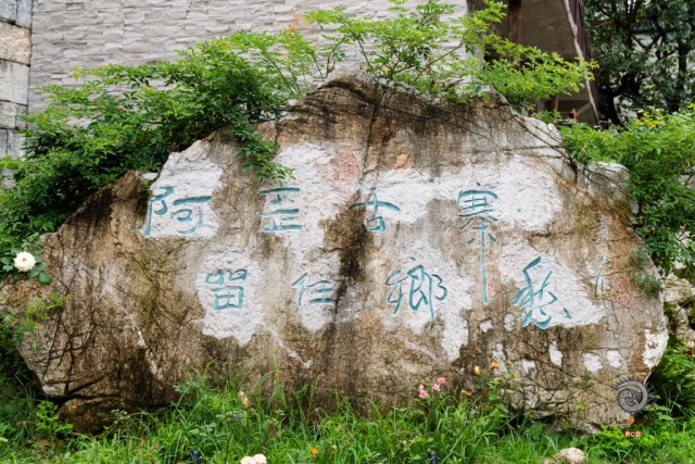 $vo['fname']|default='贵州安顺阿歪寨村是布依族传统村落，位于安顺经开区幺铺镇。该村是三国藤甲兵后裔栖居地，至今保留藤甲编织技艺。村落依山而建，石板路、石墙民居错落分布，布依族刺绣、古法造纸等非遗文化鲜活传承。
图一：古寨门庭
青灰石墙、木构老房围合石板广场，山影浮云里，静泊乡居日常。
图二：乡愁巨石
深灰巨石静卧草坡，“阿歪古寨 留住乡愁”字迹斑驳，野花攀石角，刻下乡土记忆。
图三：守寨武士
黑甲武士雕像擎黄旗立林间，藤甲头盔、长矛静指苍穹，凝住古寨精神脉络。